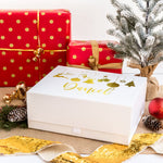 a white box sitting next to a christmas tree