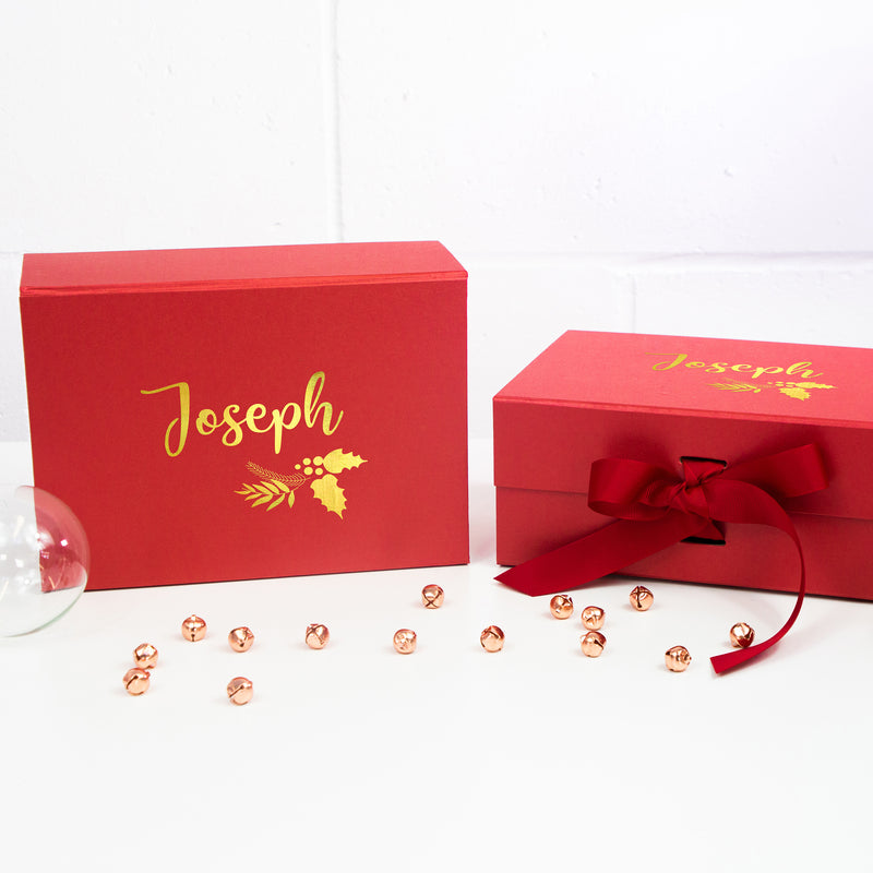 a red box with a red ribbon and some gold beads