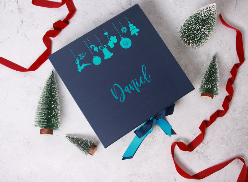 a blue box with a name on it surrounded by christmas trees