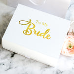 a white box with a gold foil lettering on it