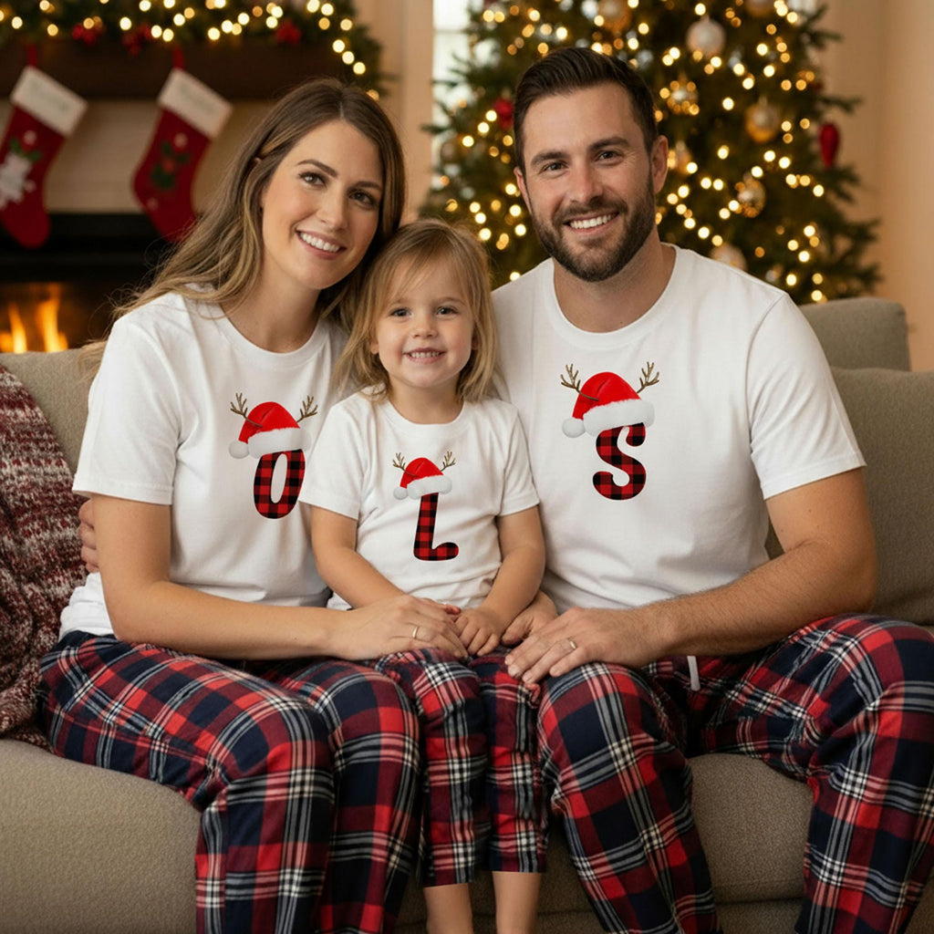 A happy family of three, consisting of a mother, father, and child, posing together in front of a Christmas tree.