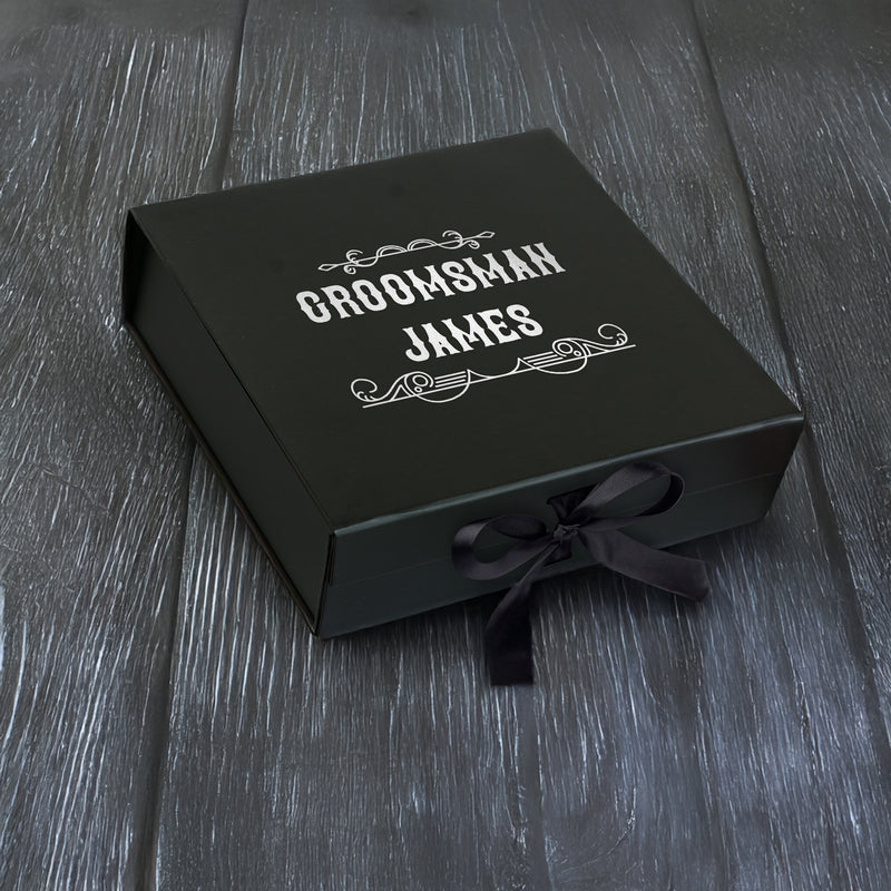 a black box with a bow on a wooden table