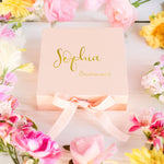 a box with a name on it surrounded by flowers