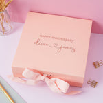 a pink box with a pink ribbon on a table