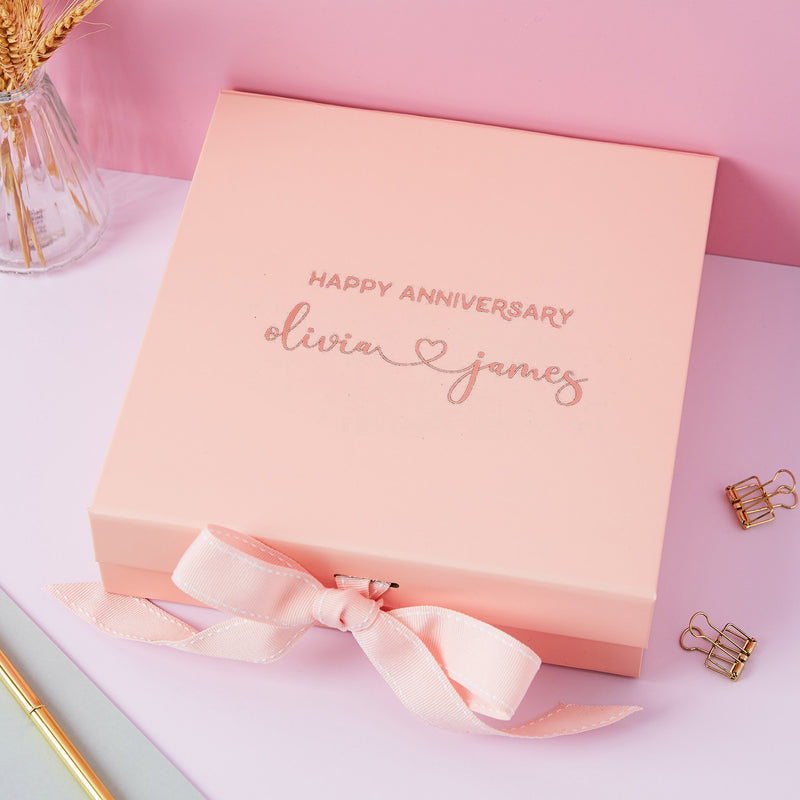 a pink box with a pink ribbon on a table