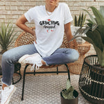 a woman sitting on a chair wearing a white shirt