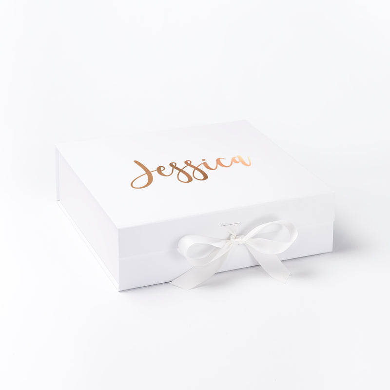 a white box with a white ribbon and a name on it