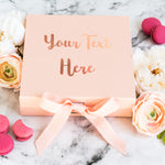 a pink box with a pink ribbon and some flowers