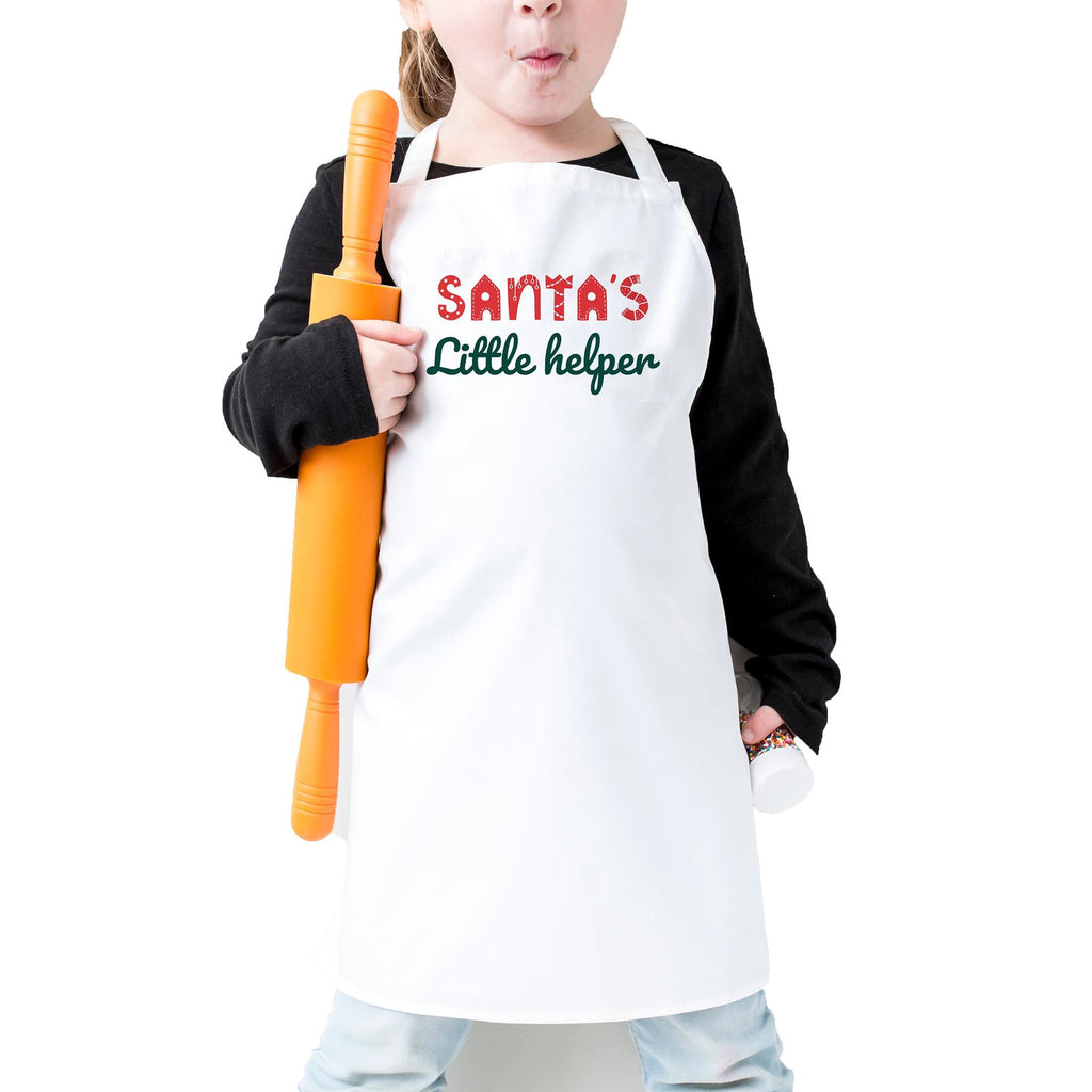 A young girl wearing a white apron with the text "Santa's Little helper" is holding an orange rolling pin.