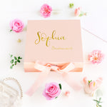 a pink box with gold lettering and pink flowers