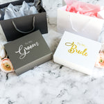 two gift bags sitting on top of a marble counter