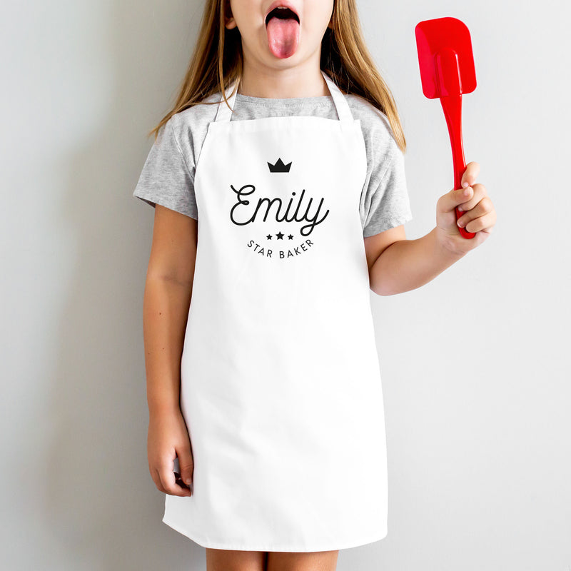 a little girl making a funny face while holding a spatula