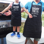 a man and a boy wearing aprons standing next to a grill