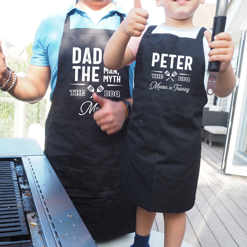 a man and a boy wearing black aprons