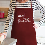 a woman wearing an apron with the words mrs smith on it
