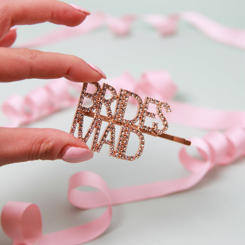 a person holding a stick with the word bride's maid on it