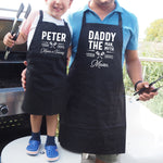 a man and a little boy wearing black aprons