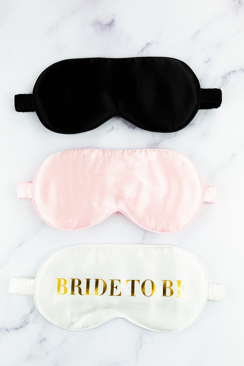 three bride to be sleep masks on a marble surface