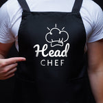 a person wearing a black apron with the words head chef on it