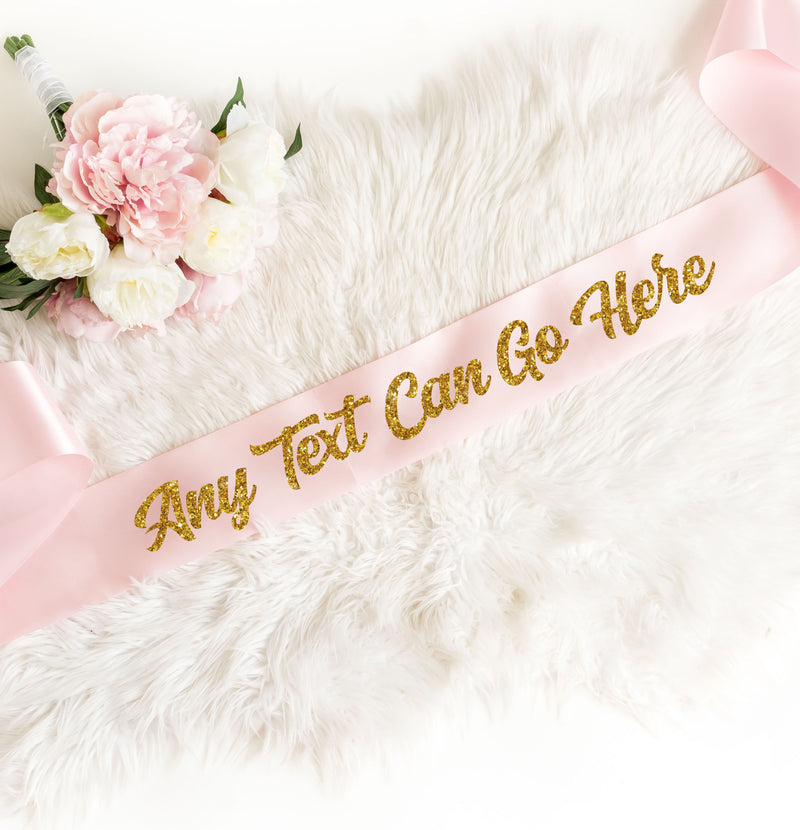 a pink sash with gold lettering on it